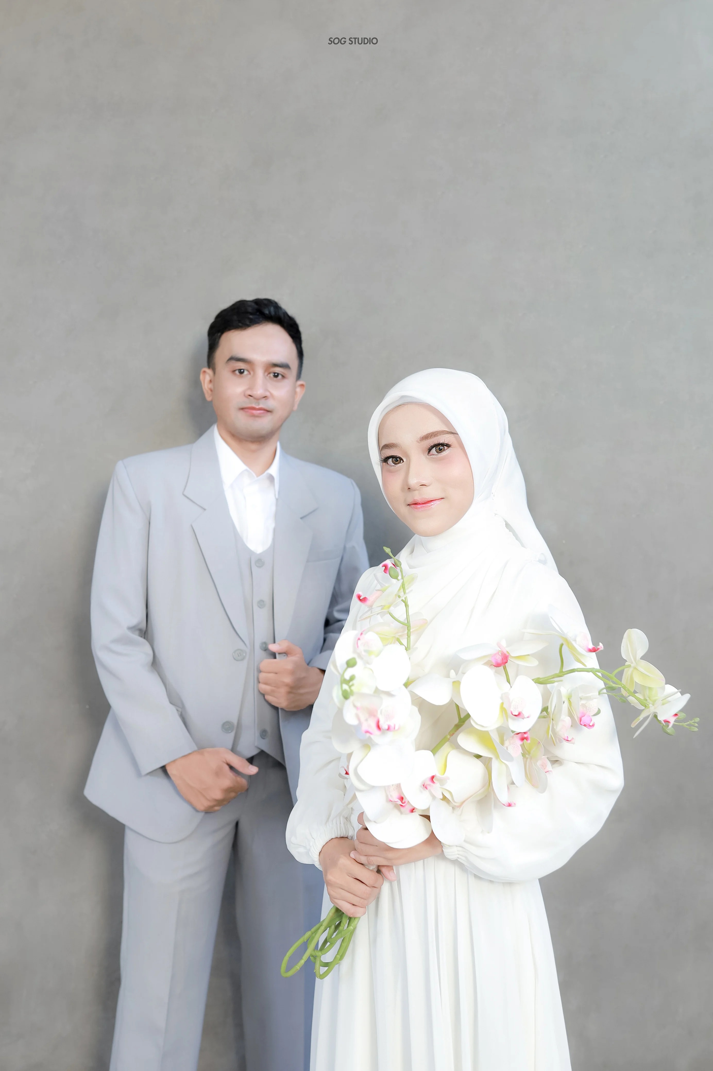 Aprilia dan Dimas berpose dengan rangkaian anggrek putih